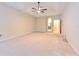 Spacious carpeted main bedroom featuring a tray ceiling, ceiling fan, and entry to a bathroom at 10212 Holland Rd, Riverview, FL 33578