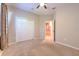This bedroom features a neutral color scheme, a ceiling fan, and a double-door closet for ample storage at 10212 Holland Rd, Riverview, FL 33578