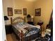 Bedroom with an iron bed frame, neutral walls, and a collection of framed art at 10212 Holland Rd, Riverview, FL 33578
