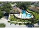 Aerial view of community pool with palm trees, lounge chairs, and clubhouse at 10212 Holland Rd, Riverview, FL 33578