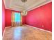 Bright dining room with tile floors, red accent wall, and elegant chandelier at 10212 Holland Rd, Riverview, FL 33578