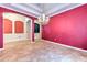Elegant dining room featuring tile flooring, a decorative chandelier, and eye-catching red accent wall at 10212 Holland Rd, Riverview, FL 33578