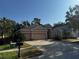 Tan single-story home with a three-car garage and well-maintained landscaping in a residential neighborhood at 10212 Holland Rd, Riverview, FL 33578