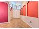 Bright foyer with a high ceiling, decorative chandelier, tile flooring, and archways framed by red accent walls at 10212 Holland Rd, Riverview, FL 33578