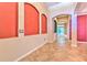 Elegant hallway featuring arched entryways, tile flooring, and custom wall niches at 10212 Holland Rd, Riverview, FL 33578