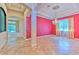 Open concept living room featuring pink walls, tile floors, tray ceilings and a large chandelier at 10212 Holland Rd, Riverview, FL 33578