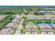 An aerial view showcases townhomes with well-manicured lawns, mature trees, a pool, and a small pond at 10329 Willow Leaf Trl, Tampa, FL 33625