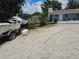 A single-story home with neutral exteriors, a gravel lot, and a boat on a trailer under a blue sky at 1114 27Th Se St # A, Ruskin, FL 33570