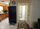 Functional kitchen area transitioning to a hallway and bathroom, featuring neutral walls and well-lit tile flooring at 1114 27Th Se St # A, Ruskin, FL 33570