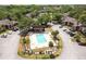 Aerial view of the community pool and clubhouse nestled among well-maintained grounds and mature palm trees at 1200 Tarpon Woods Blvd # M8, Palm Harbor, FL 34685