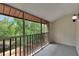Serene screened balcony overlooking a tranquil lake surrounded by mature trees, perfect for relaxation at 1200 Tarpon Woods Blvd # M8, Palm Harbor, FL 34685