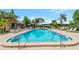 Inviting community swimming pool with lounge chairs for relaxing, surrounded by lush landscaping at 1200 Tarpon Woods Blvd # M8, Palm Harbor, FL 34685