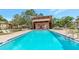 Community swimming pool and spa with ample seating, enclosed by a fence for safety and privacy at 1200 Tarpon Woods Blvd # M8, Palm Harbor, FL 34685
