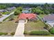 Aerial view of a home featuring a red roof, green grass, a driveway and surrounding trees at 12371 Talpa St, Spring Hill, FL 34608