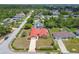 View of a single-story home with a red roof and mature trees surrounding a quiet neighborhood at 12371 Talpa St, Spring Hill, FL 34608
