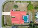 Birds eye view of a single-story home with an enclosed pool, red roof, and manicured lawn at 12371 Talpa St, Spring Hill, FL 34608