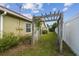 Backyard featuring green grass, white fence, a wooden pergola and the home's exterior at 12371 Talpa St, Spring Hill, FL 34608