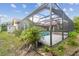 Backyard with green grass and plants featuring an enclosed swimming pool at 12371 Talpa St, Spring Hill, FL 34608