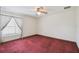Bedroom with plush red carpet features neutral walls and ceiling fan at 12371 Talpa St, Spring Hill, FL 34608