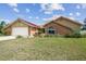 Single-story home featuring brick accents, light yellow siding, and a well-manicured front yard at 12371 Talpa St, Spring Hill, FL 34608