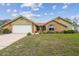 Charming single-story home featuring brick accents, light yellow siding, and a well-manicured front yard at 12371 Talpa St, Spring Hill, FL 34608
