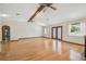 Bright living room features hardwood floors, neutral paint, ceiling fans, and glass doors to the exterior at 12371 Talpa St, Spring Hill, FL 34608