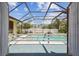 View of the screened-in pool from the open patio doors showing the backyard at 12371 Talpa St, Spring Hill, FL 34608