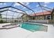 Screened-in pool with spa, red tile trim, white fence, and exterior windows above at 12371 Talpa St, Spring Hill, FL 34608