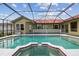 Screened-in pool area with a jacuzzi and exterior view of the home at 12371 Talpa St, Spring Hill, FL 34608