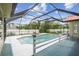 Screened-in pool with lush foliage around the perimeter and red tile roof at 12371 Talpa St, Spring Hill, FL 34608