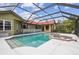Screened-in pool area with a jacuzzi and exterior view of the home with a red roof at 12371 Talpa St, Spring Hill, FL 34608