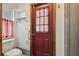 Toilet area featuring the toilet, door, shelves, and shower at 12371 Talpa St, Spring Hill, FL 34608