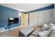 Relaxing bedroom with blue walls, comfortable seating, TV, and closet with bi-fold doors at 143 Lakeside Dr # 143, Oldsmar, FL 34677