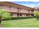 Exterior elevation with well-maintained lawn, shrubs, and a balcony on the upper level at 143 Lakeside Dr # 143, Oldsmar, FL 34677