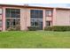 Building exterior featuring lush greenery, a well-maintained lawn, and screened lanais at 143 Lakeside Dr # 143, Oldsmar, FL 34677