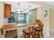 Charming kitchen bar with pendant lighting, open to the living space with wood bar top and stools at 143 Lakeside Dr # 143, Oldsmar, FL 34677