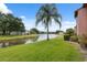 Scenic water view with lush green lawn, palm tree, and clear blue sky at 143 Lakeside Dr # 143, Oldsmar, FL 34677