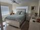 Cozy bedroom featuring a queen-sized bed, a ceiling fan, and an abundance of natural light from two windows at 1447 Lemon Bay Dr, Englewood, FL 34223