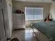 Comfortable bedroom featuring a queen bed, dresser, and a bright window, offering a relaxing retreat at 1447 Lemon Bay Dr, Englewood, FL 34223