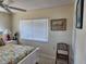 Bright bedroom featuring a white wood bed with colorful floral bedding, side table, and decorative art at 1447 Lemon Bay Dr, Englewood, FL 34223