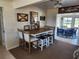 Comfortable dining area featuring a wooden table with chairs and stools, complemented by unique wall art at 1447 Lemon Bay Dr, Englewood, FL 34223