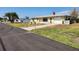 Charming single-story home with a well-maintained yard, driveway, and a glimpse of the neighborhood street at 1447 Lemon Bay Dr, Englewood, FL 34223