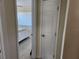 Hallway view leading to a bright bedroom, with tile flooring and white walls, enhancing the home's appeal at 1447 Lemon Bay Dr, Englewood, FL 34223
