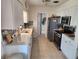 Modern kitchen with stainless steel appliances, white cabinetry, mosaic backsplash, and ample counter space at 1447 Lemon Bay Dr, Englewood, FL 34223