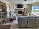 Comfortable living room with a fireplace, neutral-toned furniture, and a large window at 1447 Lemon Bay Dr, Englewood, FL 34223