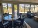 Sunny sunroom featuring blue wicker furniture and large windows with views of the surrounding landscape and waterfront at 1447 Lemon Bay Dr, Englewood, FL 34223