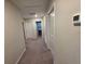 Well-lit hallway featuring neutral walls, carpet flooring and white doors at 1561 Flower Dust Dr, Ruskin, FL 33570