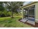 A cozy screened-in patio with a grill overlooks a green backyard with beautiful landscaping at 1713 Trailwater St, Ruskin, FL 33570