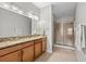 Spacious bathroom featuring double vanity, granite countertops, and a glass-enclosed shower at 1713 Trailwater St, Ruskin, FL 33570