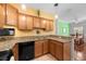 Functional kitchen featuring granite counters, wooden cabinets and modern black appliances at 1713 Trailwater St, Ruskin, FL 33570